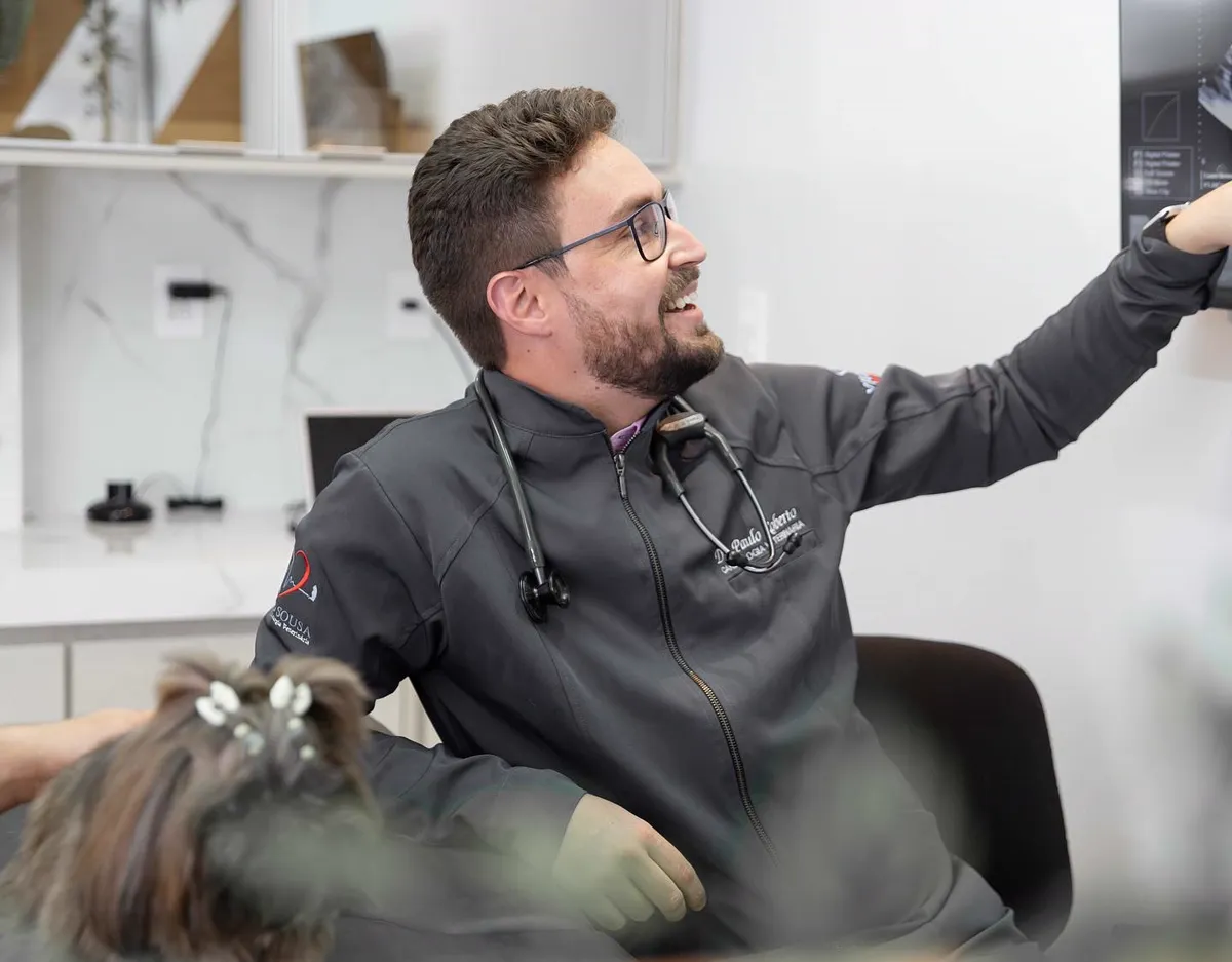 Dr. Paulo Sousa analisando o exame de imagem ao lado do paciente